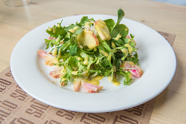 a plate of salad with apples and cheese