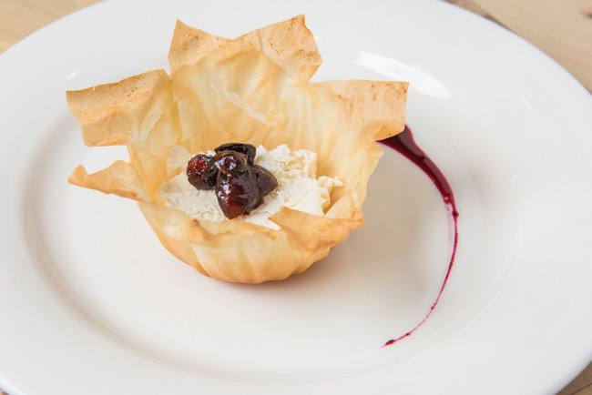 a pastry with cream cheese and berries on a white plate