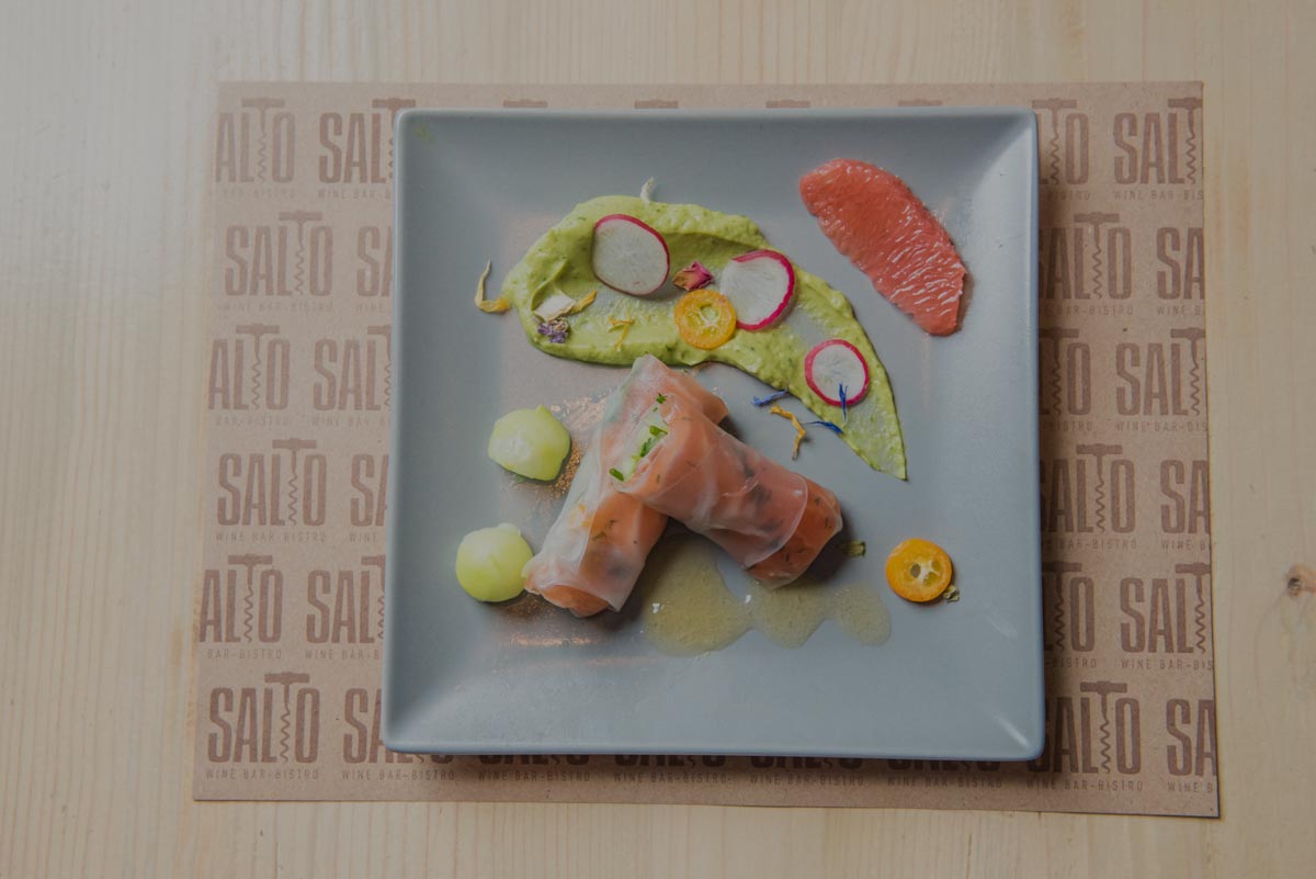 A plate from Salto Wine Bar contains delicious food with salmon, avocado and kumquat